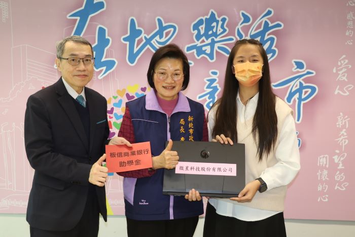 《圖說》板信銀行副總經理黃家泰(左)捐贈助學金,李美珍局長代表微星科技捐贈筆電給小亭。〈社會局提供〉